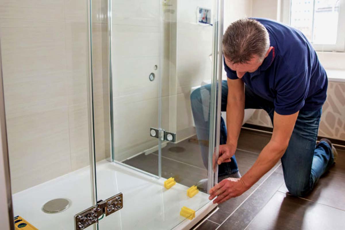 plumber installing glass shower